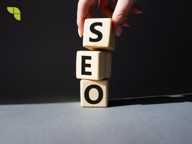 A hand holding a white blocks with the word SEO on it